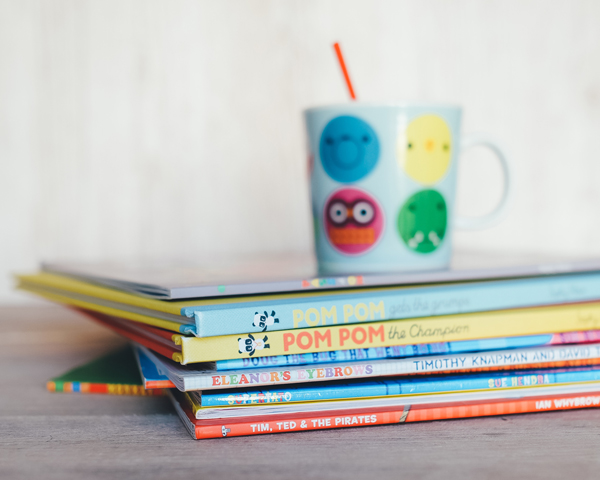 children's cup on top of preschool books